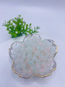Macro shot of 8mm gradient glass beads in a gold-rimmed bowl for DIY jewelry making