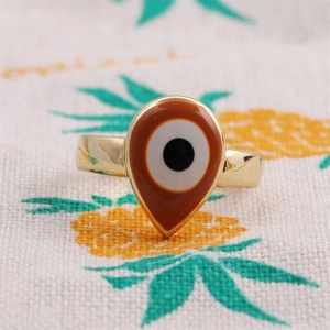 Vue macro d'une bague goutte œil protecteur dorée avec détails raffinés en émail brun