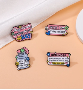 Close-up of four enamel mental health pins on orange background with white silk