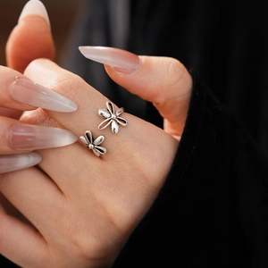 Detail of vintage hollow flower open ring in silver finish worn on the finger