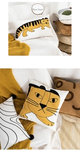 Detail of modern animal embroidery throw pillow with tufted yellow tiger pattern