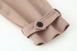 Detail of camel wool jacket sleeve featuring black resin button and decorative cuff strap