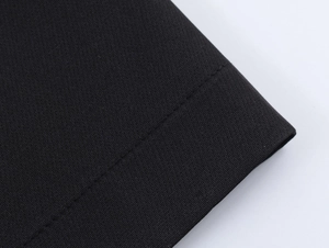 Gros plan sur la texture du tissu tissé noir avec coutures de robe à double boutonnage
