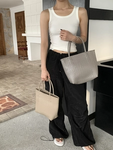 On-body shot of large woven straw tote bag in grey and beige minimalist summer style