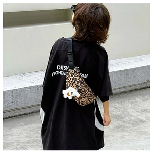Close-up of leopard print chest bag with adjustable strap and cute bear plush charm