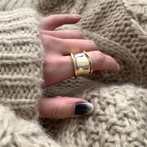 Polished gold wide irregular ring styled on a model with a cozy beige knit sweater