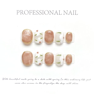 Detail of peach marble press-on nails with hand-painted green leaf patterns and gold foil edges