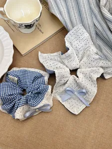 Detail of blue plaid and lace scrunchies with pearls on rustic linen fabric