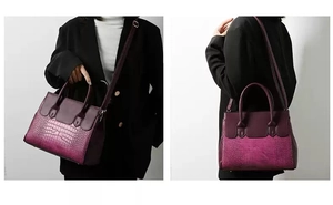 Detail view of deep purple crocodile embossed handbag with adjustable strap and handles