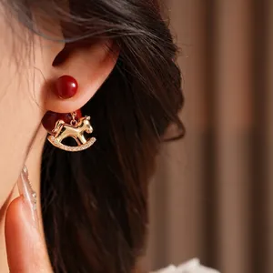 Exquisite gold-plated rocking horse earrings with red beads and shimmering zircons