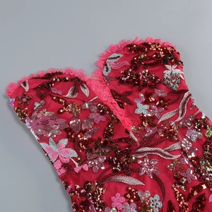 Close-up of red sequin embroidery and floral lace details on a formal evening dress