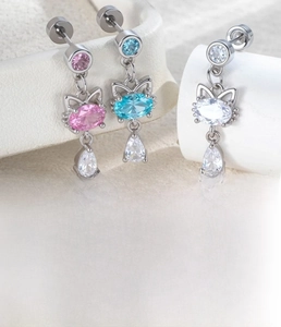 Macro view of cat-shaped zircon earrings in pink, blue, and white with silver plating