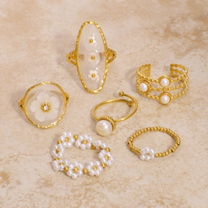 Set of six gold stainless steel rings featuring white pearls and elegant flower designs