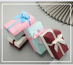 Macro detail of textured rectangular gift boxes with elegant ribbon bow decorations
