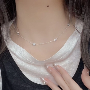 Close-up of 925 sterling silver daisy flower necklace worn on a woman's collarbone
