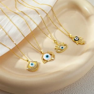 Gold Evil Eye and Hamsa Hand necklaces set with blue enamel and sparkling zircons