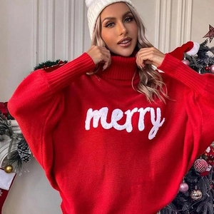 Close-up of red Christmas turtleneck sweater with merry script and knit textures