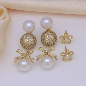 Three pairs of vintage gold pearl and crystal stud earrings in a French fashion style