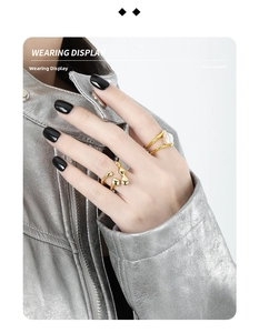 Irregular golden layered ring set with baroque pearl worn on a model in silver jacket