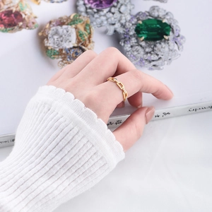 Detailed view of a gold chain ring with sparkling micro-pave cubic zirconia on a model