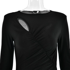 Detalle del vestido negro de manga larga con diseño de pliegues y detalle de abertura