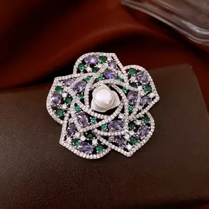 Exquisite vintage flower brooch with purple zircons and central pearl on a leather background