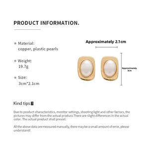 Detail view of gold-plated oval stud earrings with pearl inlay and 3cm size dimensions