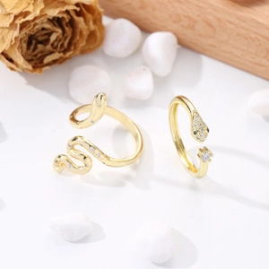 Detailed macro shot of gold snake-shaped rings set with sparkling cubic zirconia accents