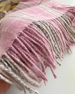 Gros plan d'une écharpe à carreaux rose et blanc montrant la texture douce et les franges