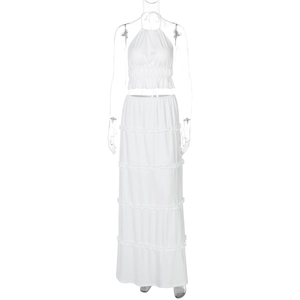 Detail of white two-piece set featuring halter crop top and tiered ruffle maxi skirt