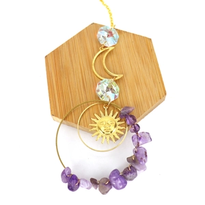 Solar crystal suncatcher with golden moon and amethyst stones on a wooden base