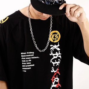 Macro shot of silver stainless steel chain link necklace on a black streetwear t-shirt