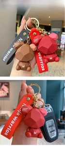 Detail view of red and brown geometric low-poly bear keychains with logo wrist straps