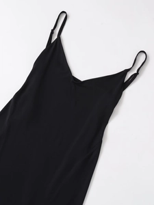 Detail view of smooth black crepe fabric and neat stitching on a long camisole dress