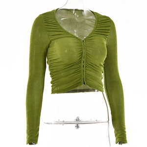 Détail du crop top vert ajusté avec manches longues et design plissé sur le buste