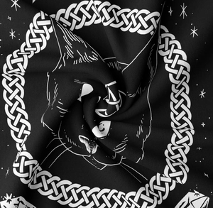 Macro shot of mystical black cat tapestry fabric showing twill texture and star print