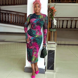 Detail of elegant floral print long sleeve slim fit midi dress on a standing model