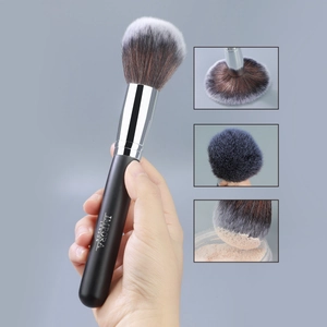 Macro view of fluffy synthetic powder brush bristles with white tips and black handle