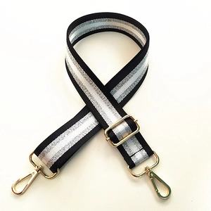 Detail of adjustable black and white striped bag strap with gold glitter metallic hardware