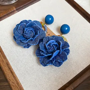 Boucles d'oreilles roses en jean bleu élégantes avec tiges en argent sur présentoir