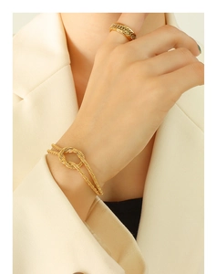 Close-up of gold-plated twisted chain bracelet and matching Cuban ring on model