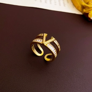 Bague double couche plaqué or en V avec zircons sur fond de cuir marron élégant