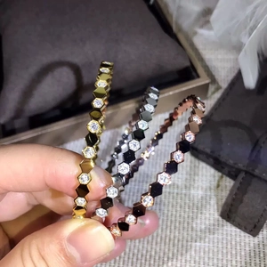 Detailed view of honeycomb bracelets in gold, silver, and rose gold with inlaid crystals