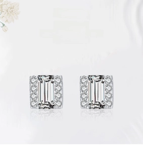 Macro shot of square emerald-cut zircon earrings with brilliant side stones in 925 silver