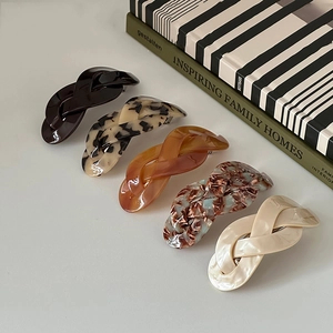 Close-up of five twisted French style hair clips in marble and leopard patterns