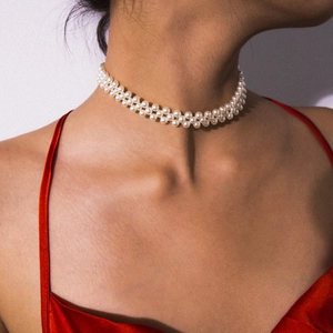Close-up of elegant double-row pearl choker necklace on model with red satin dress
