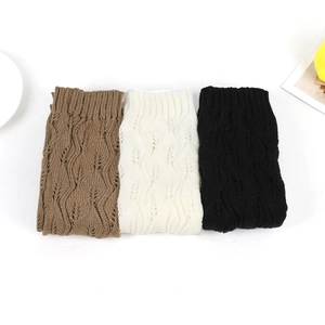 Three pairs of thick knit leg warmers in brown, beige, and black with hollow leaf patterns
