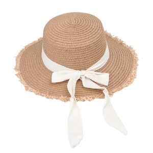 Detailed top view of wide brim straw hat showing white ribbon bow and fringed edge texture