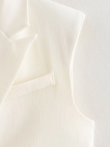Macro detail of white woven fabric on a sleeveless vest featuring lapel and pocket