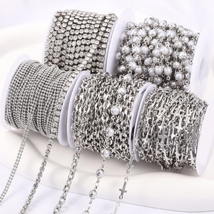 Detail of silver DIY chain assortments with rhinestones and pearls on white spools